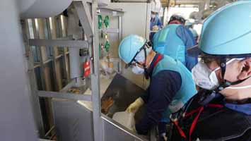 多核種移送設備建屋にて採水している様子（韓国の分析機関関係者）
