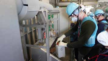 多核種移送設備建屋にて採水している様子（ロシアの分析機関関係者）