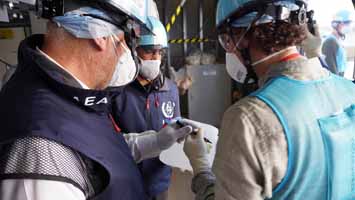 採取したALPS処理水に署名をするIAEA関係者
