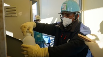 希釈・放出設備で採水している様子（IAEA関係者）