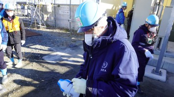 採取したALPS処理水に署名をするIAEA関係者