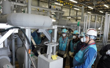 多核種移送設備建屋にて採水について説明をしている様子