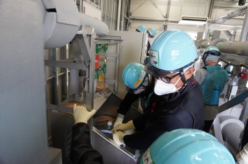 多核種移送設備建屋にて採水している様子（韓国の分析機関関係者）