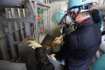 多核種移送設備建屋にて採水している様子（中国の分析機関関係者）