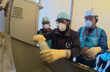 希釈・放出設備にて採水している様子（IAEA関係者）