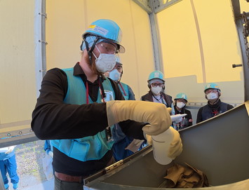 希釈・放出設備にて採水している様子（スイスの分析機関関係者）