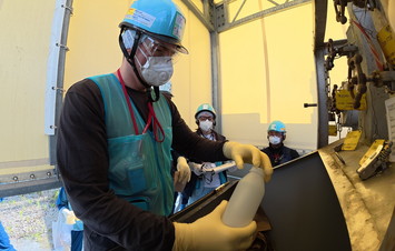 希釈・放出設備にて採水している様子（ロシアの分析機関関係者）