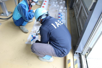 採取した試料に署名をするIAEA関係者①