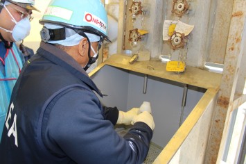 希釈・放出設備にて採水している様子（IAEA関係者）