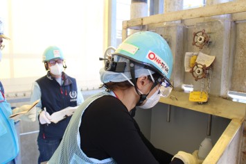 希釈・放出設備にて採水している様子（ロシアの分析機関関係者）