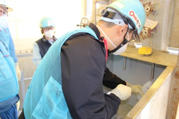 希釈・放出設備にて採水している様子（中国の分析機関関係者）